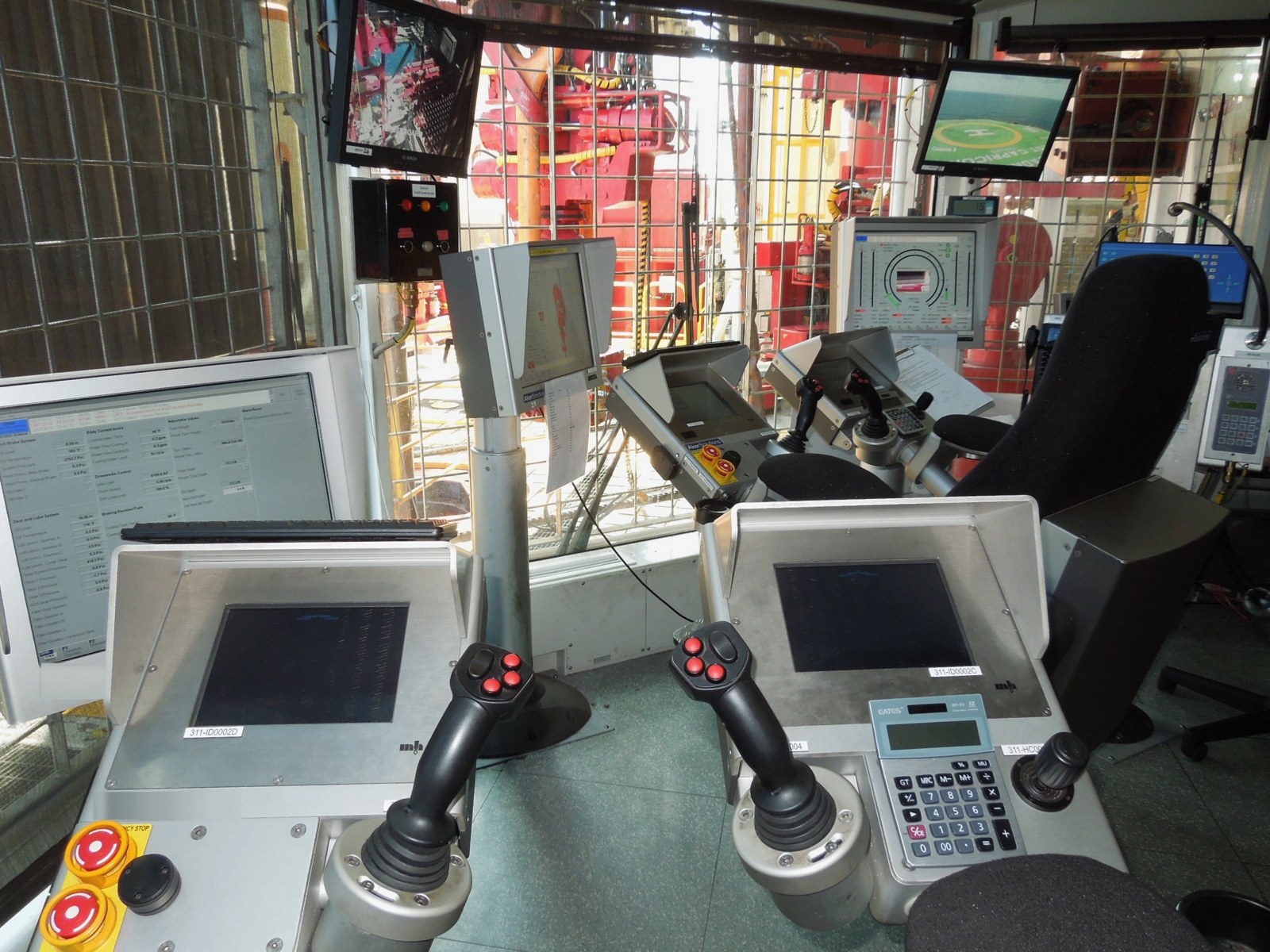 Drill cabin on a drillship with the driller's consoles and a view of the rig floor
